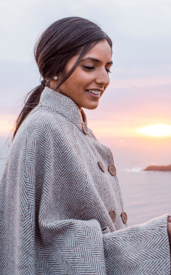 Woman by the coast looking at mobile phone