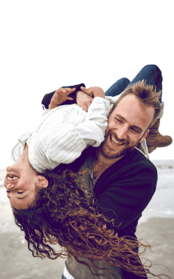 A father plays with his daughter on the beach